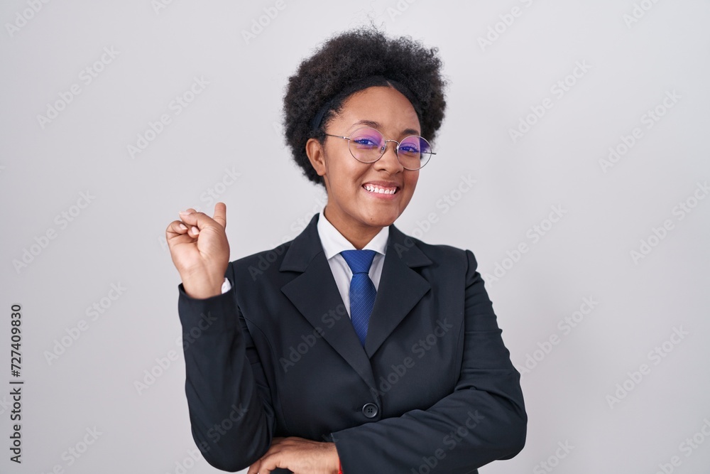 Poster Beautiful african woman with curly hair wearing business jacket and glasses smiling with happy face winking at the camera doing victory sign with fingers. number two.