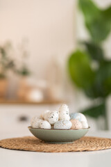 Painted Easter eggs in a plate on a white table. Kitchen background