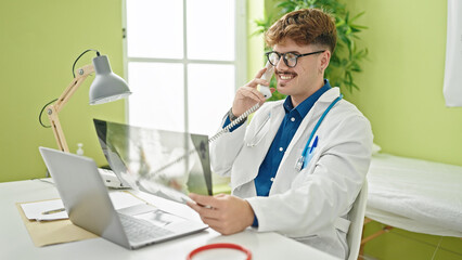 Young hispanic man doctor talking on telephone holding xray at the clinic