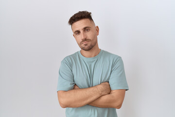 Obraz premium Hispanic man with beard standing over white background looking sleepy and tired, exhausted for fatigue and hangover, lazy eyes in the morning.