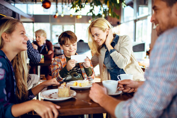 Young family having coffee and cake in a cafe