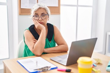 Middle age grey-haired woman business worker stressed using laptop at office