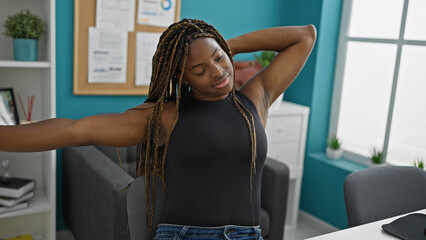 African american woman business worker stretching arms smiling at the office