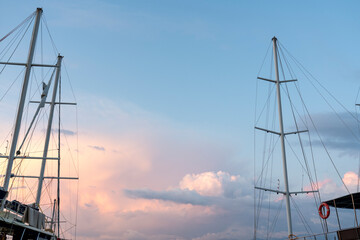 The mast of a sailing ship against a clear blue sky. Ropes, rope ladders and other gear are visible.