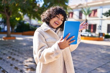Fototapeta premium Young beautiful hispanic woman smiling confident having video call at park