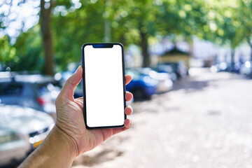 Man holding smartphone showing white blank screen at street
