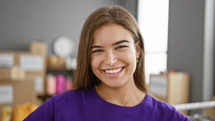 Confident beautiful hispanic young woman smiling as a volunteer at a charity center