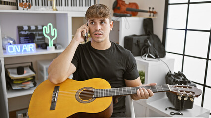 Handsome young hispanic male artist engrossed in a serious conversation on his smartphone at a...