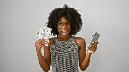 African american woman smiling holding dollars and smartphone over isolated white background