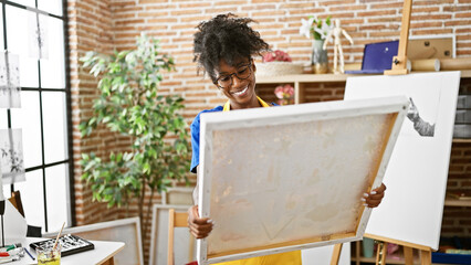 African american woman artist smiling confident looking draw at art studio