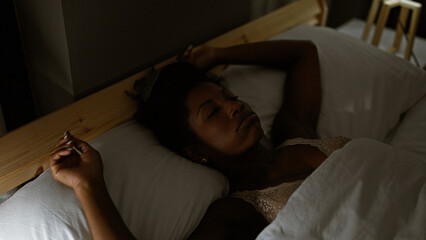 African american woman lying on bed sleeping at bedroom