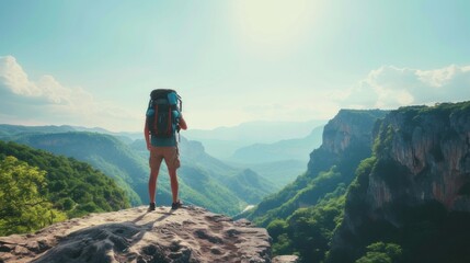 Man with backpack, traveller or explorer standing on top of mountain or cliff and looking on valley. Concept of discovery, exploration, hiking, adventure tourism and travel - obrazy, fototapety, plakaty