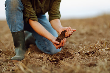 Farmer holding soil in hands close-up.Farmer is checking soil quality before sowing wheat....