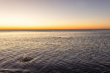 Obraz premium Sunrise on sea golden blue colors, Stones at sunset with blur, selective focus