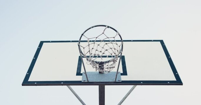 Basketball, net and shot for success outside with a competitive sport for athletics. Below, ball and fitness game with a hoop for scoring and training for health and wellness with equipment outdoors