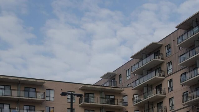 residential building corner clouds time lapse urban development modern city life concrete balconies
