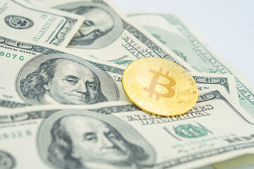Gold Bitcoin on hundred dollars bills. Golden symbolic coin Bitcoin on banknotes of one hundred dollars. Cryptocurrency on US dollar bills. Digital modern method of payment. Exchange bitcoin cash