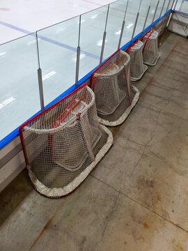 Hockey nets sitting at the side of a ice rink.