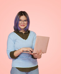 Friendly female student with laptop smiles against cheerful pink background. Dedicated and...