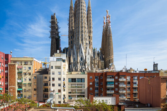 Barcelona, Spain - April 11 2023 :  Incredible detail of the sagrada familia facade in high resolution with architectural detail of the iconic landmark and unique view by residential home properties