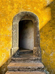 Old stone steps and passage on the yellow wall of the National Palace of Pena in Sintra