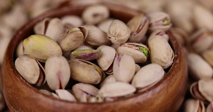Salted fried pistachios on the table, pistachio nuts close-up