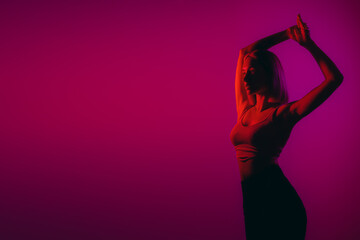 Dynamic and poised, a woman's figure is highlighted by a vivid magenta backlight
