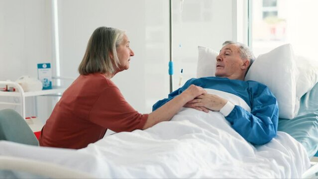 Senior woman, hospital and husband in bed with cancer, illness or sick in conversation for support. Elderly patient, man and couple with talk, empathy or comfort in retirement with anxiety in clinic