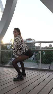 Hot girl dancing twerk in the city. A beautiful woman dances erotically with her buttocks.