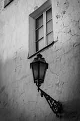 A street lamp on the wall of a house in the old center of Vilnius. A lamp and a window