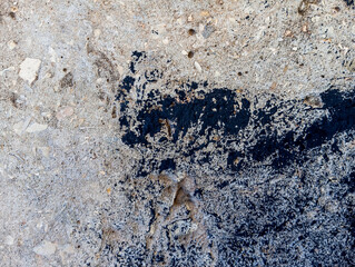 Abstract black paint grunge background. Dirty cement wall with black paint stains and blobs.