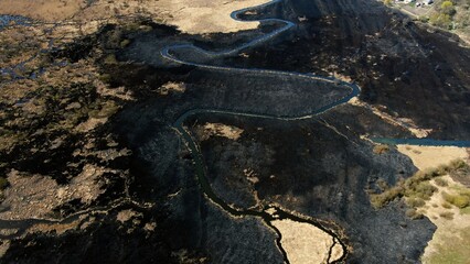 Aerial View of Serpentine Waterway Cutting Through Burnt Landscape