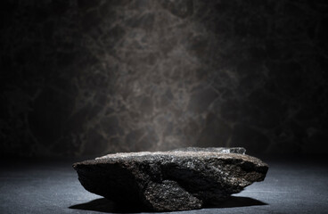 granite stones for the podium. black natural stones with texture on a dark background for a minimalist podium for the presentation of a product: cosmetics, medicine, perfumery, body care, jewelry - obrazy, fototapety, plakaty
