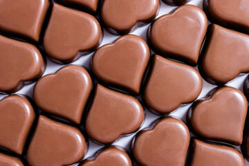 Pattern of real milk chocolates in shape of heart. Valentine's Day background. Selective focus