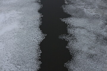 The ice-covered surface of the reservoir. An icy river in winter. A pond in frosty cold weather