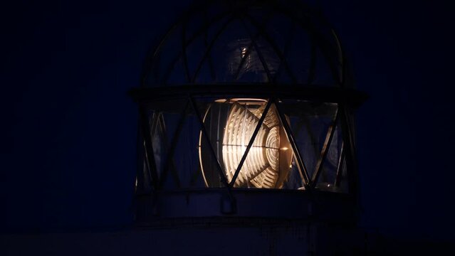 Detail view. Lighthouse with beacon light in the night. Faro Cabo Busto on Asturias coast in Spain. Tourist attraction, place to visit.