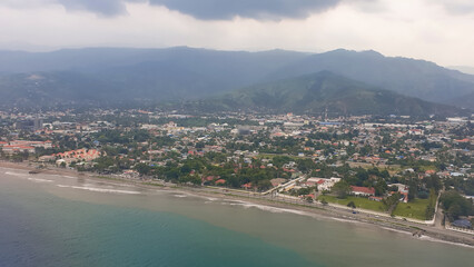Fototapeta premium Scenic panoramic aerial view of the urban capital city of Dili with houses, buildings, ocean, beach and mountains in Timor-Leste, Southeast Asia 
