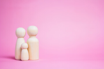 Family wooden puppets on pink background Life insurance ideas for future financial security and...