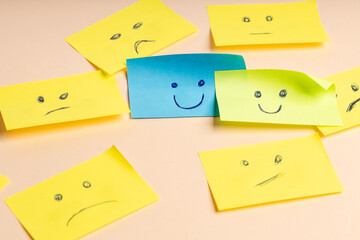 Colorful cards with drawn faces expressing emotions of satisfaction and anger