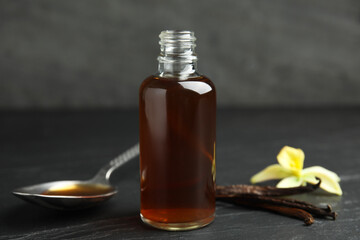 Aromatic homemade vanilla extract on black table