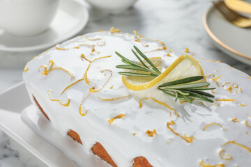 Tasty lemon cake with glaze and rosemary on table, closeup
