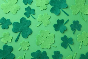 St. Patrick's day. Decorative clover leaves on green background, flat lay