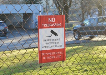no trespassing danger sign on  chainlink fence DSLR photo  