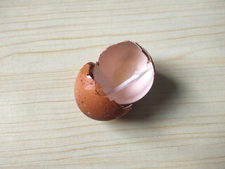 brown egg shell broken or crack with pieces scattered on the surface,