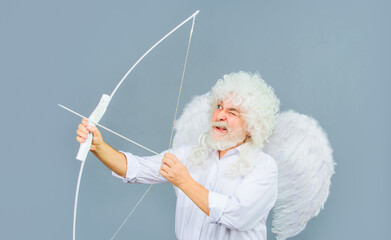 Valentine angel in white wig aiming with bow. Symbol of love. Valentines day cupid in angel wings...