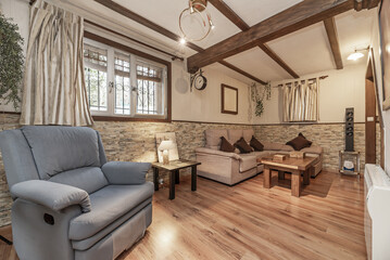 A small living room on the ground floor of a detached house with fabric upholstered sofas, wooden...