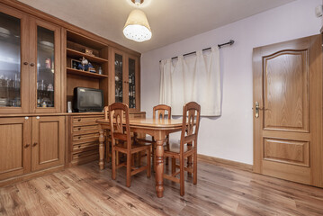 Small dining room in a home with matching table and chairs, wooden floors,
