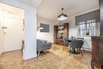 Living room of a ground floor apartment with a gray fabric divan sofa, wooden bookcases