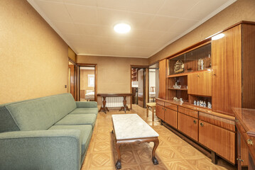 living room of a house with vintage-style wooden furniture and brown stoneware floors similar to parquet