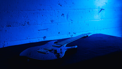 Guitar background with blue lights. Music guitar equipment on the black table